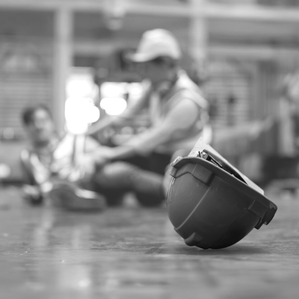 SINGLE-IMAGE_hard-hat-with-blurred-injured-factory-workers-expanded_jun25