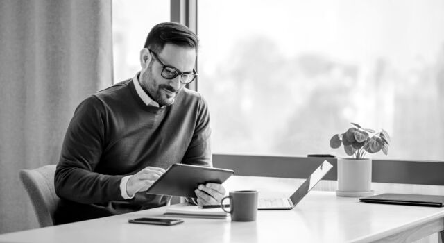SINGLE-IMAGE_man-with-tablet-at-desk-with-plant_feb24