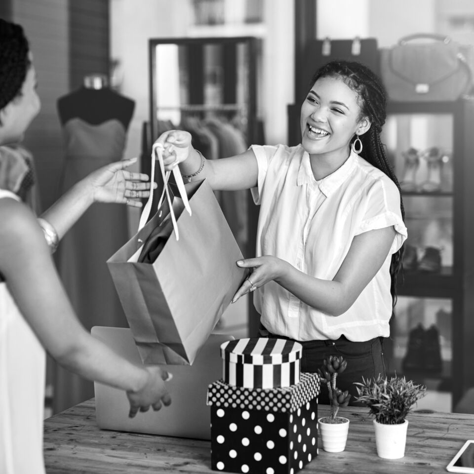 SINGLE-IMAGE_shop-clerk-handing-bag-to-customer_aug25