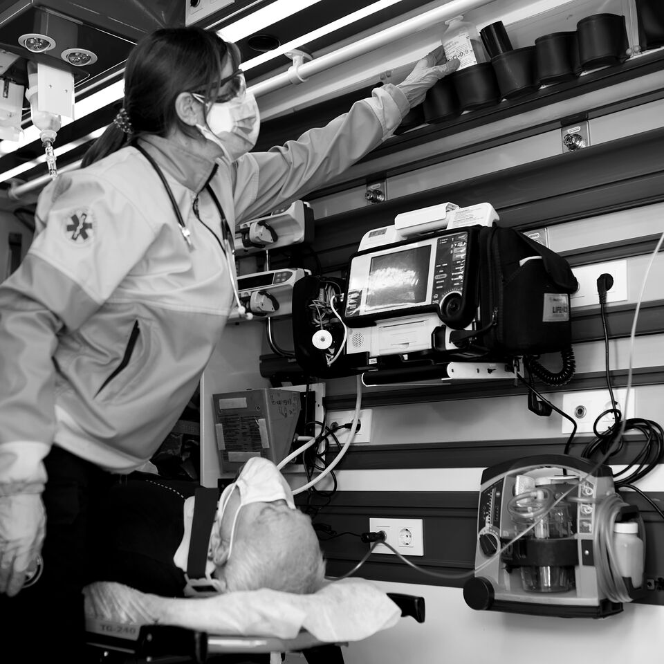 SINGLE-IMAGE_female-paramedic-aiding-male-patient-on-stretcher-black-and-white_