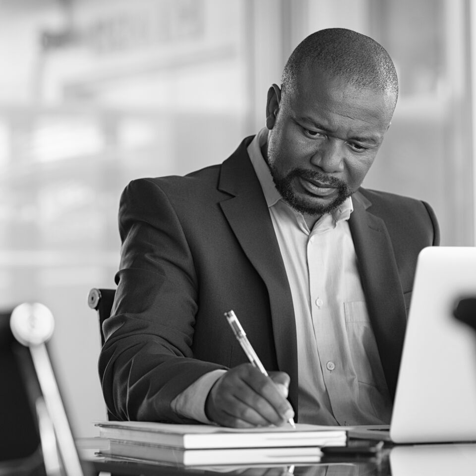 SINGLE-IMAGE_man-with-pen-and-books-at-desk_feb24